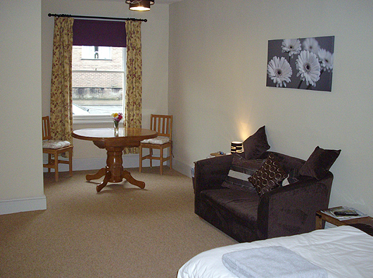 Guest House room with dining table and comfortable sofa at Coach and Horses Guest House in Llanidloes Powys